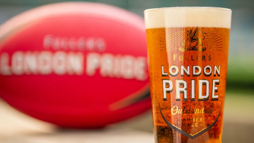 Pint of Fuller's London Pride with a merch rugby ball in the background